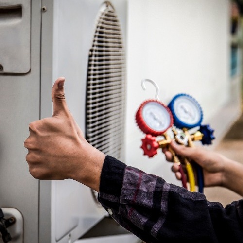 HVAC repairman calibrates outdoor unit