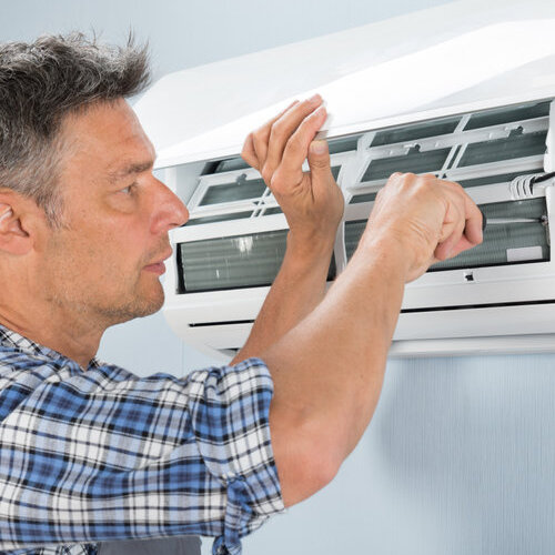 Portrait Of Mid-adult Male Technician Repairing Air Conditioner
