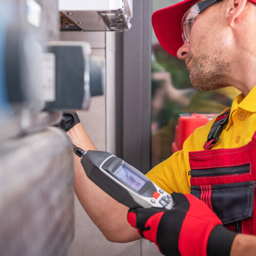 Caucasian Technician in His 40s with Gas Leak Detector Performing Scheduled Check and Heating Furnace Maintenance. HVAC Worker