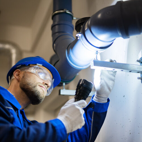 PVC Water Pipe Inspection By Construction Worker