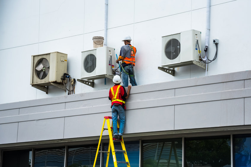 Air Conditioning Technician are servicing air conditioners.